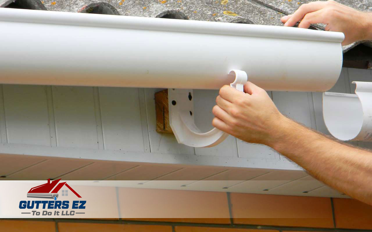 Installing gutter hangers along the roof line.